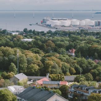 Aerial view of a coastal area showing homes, industry, and wind turbines