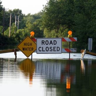 Flooded road with "high water, road closed" signs