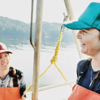 two smiling women fishers on a fishing boat
