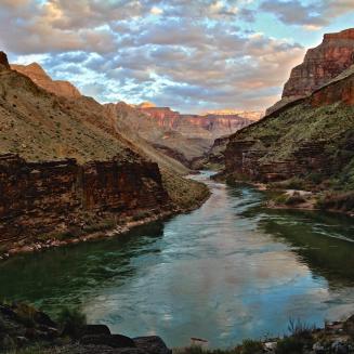 Scenic view of a river in the Grand Canyon with colorful clouds in the sky
