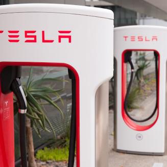 A row of Tesla charging stations in a parking lot