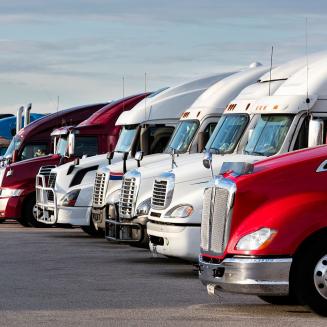 A row of semi trucks lined up like a hero shot in a Transformers movie. Autobots, roll out!