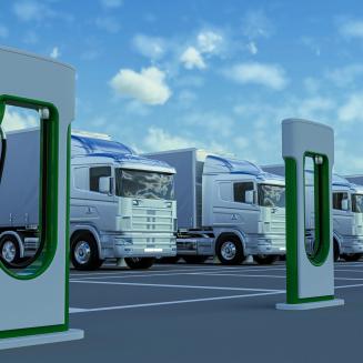 Row of electric trucks with charging stations in front of them