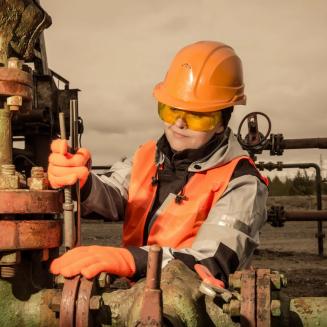 Female oil and gas worker working on machinery