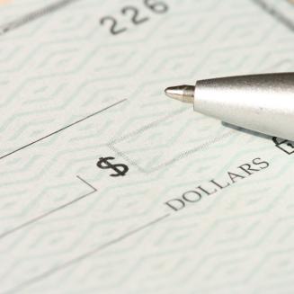 Close view of a bank check with a pen