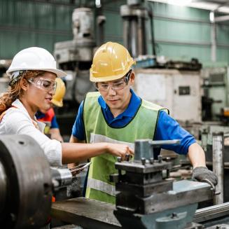 Workers in a factory looking at machinery
