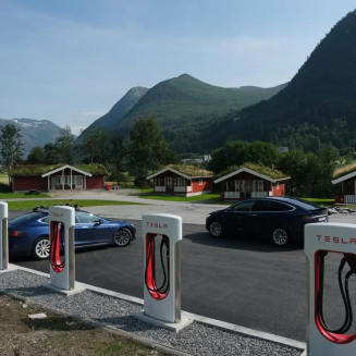 Tesla cars stand at a Tesla Supercharger charging station