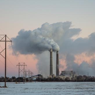 Xcel Energy's Sherburne County (Sherco) Generating Station, a coal-fired power plant, near Becker, Minnesota, shown with snow on the ground and a pink sky.