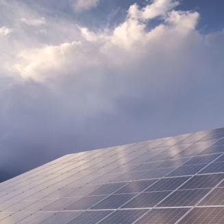 Solar panels in front of a cloudy sky