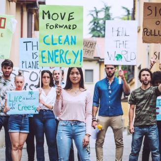 Diverse crowd protesting about clean energy