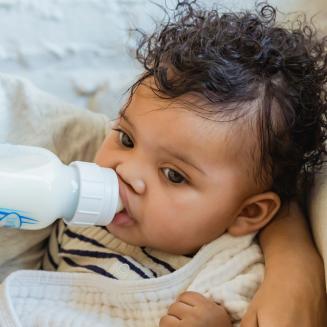 Baby drinking from plastic bottle