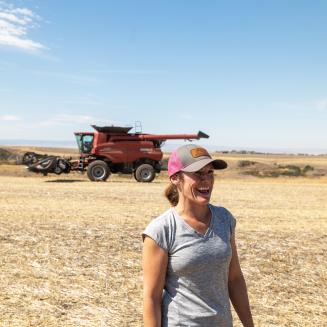 Cori Whittman standing in front of a red tractor on her family farm in Idaho