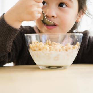 Girl eating cereal from bowl