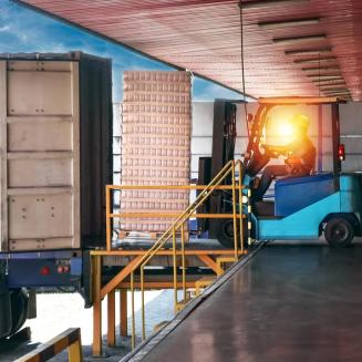 A forklift driver loading or unloading goods onto a truck.