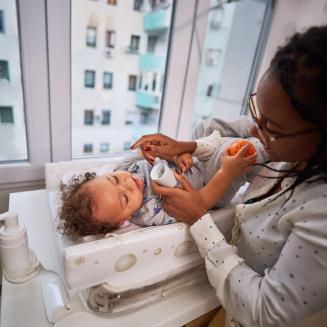 A mother applying lotion to her baby