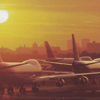 Planes on runway with sunset in background