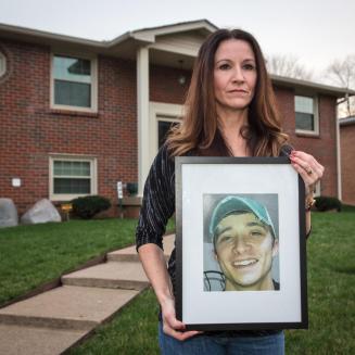 A mother holds a photo of her son.