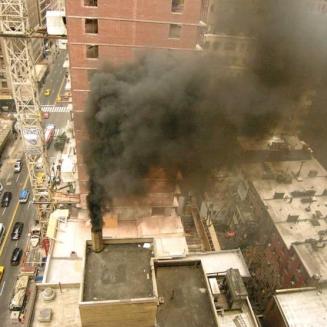 Black smoke billows out of a building's chimney in New York City
