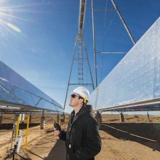 Man looking up towards a large solar panel
