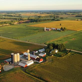 A farm with red barns and silos, viewed from overhead.