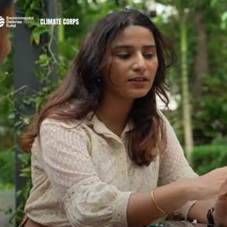 A former Climate Corps fellow works at a computer outdoors.
