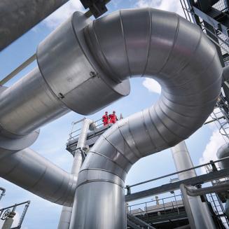 Gas workers overlooking pipes
