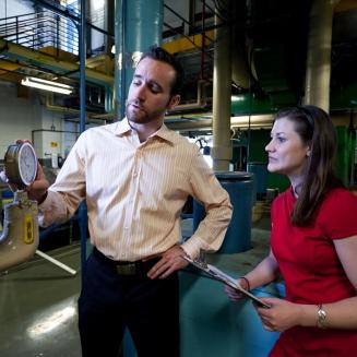 Man pointing at a meter while talking to a woman