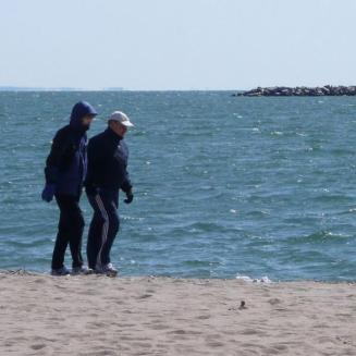2 people walking on a beach