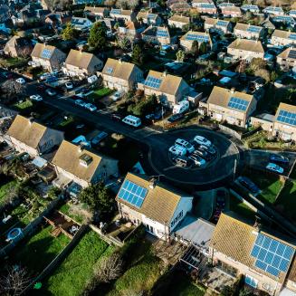 A row of British houses with solar panels on the roofs.
