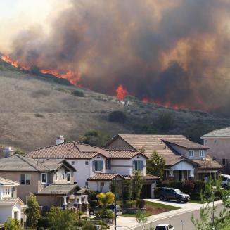 Brush fire burning near hillside homes.