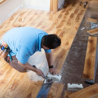 Man installing floor panels in a house