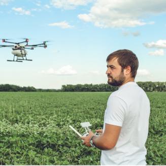 Man operating a drone in a grass field
