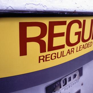 An old gasoline pump that reads: regular leaded gasoline.