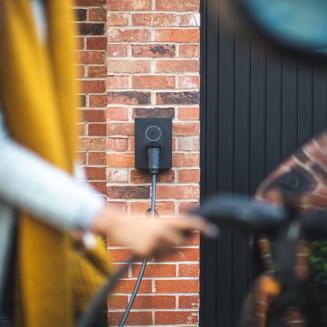 A person plugging a charger into an electric vehicle