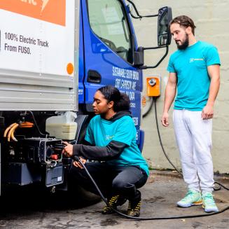 Two people charging an electric truck.