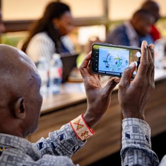 Workshop participant holding up a smartphone to photograph a presentation.
