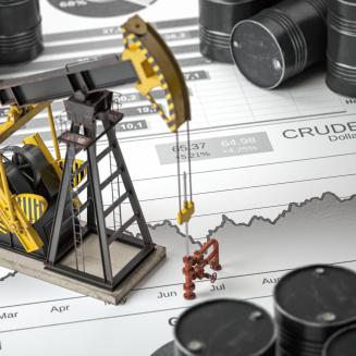 Miniature oil pumpjack and drilling equipment positioned on top of a crude oil price chart, surrounded by black oil barrels. The chart, labeled “CRUDE OIL Dollar,” shows a rising trend over several months, symbolizing oil production, commodity markets, and fluctuations in energy prices.