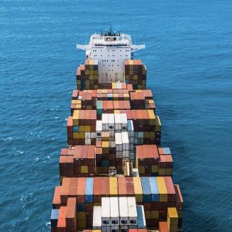 Cargo ship on water, viewed from above.