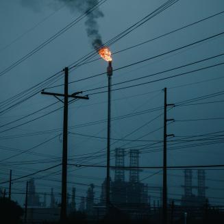 A flare stack visible on an overcast evening