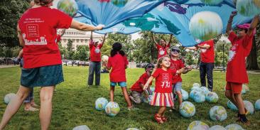 Moms playing with kids in Kids Clean Air Force t-shirts in front of the U.S. Capitol Building