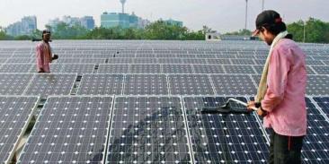 Two people work on an array of solar panels