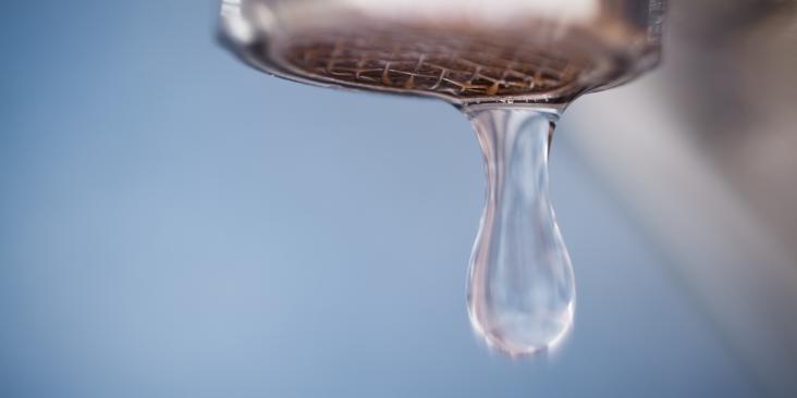 A close up of water dripping out of a faucet