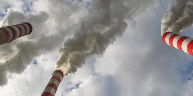 Smokestacks against a cloudy sky.