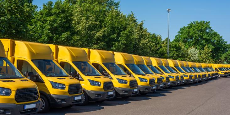 A fleet of electric yellow delivery vans