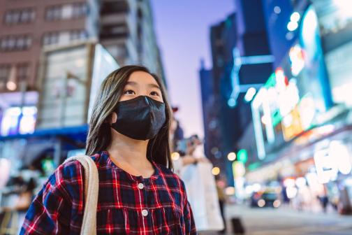 Person in a protective face mask on a city street.