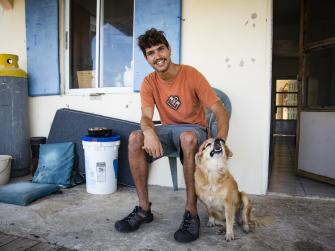 Culebra resident Nicolas Gomez on his porch with his dog