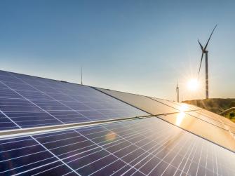 solar panels and wind turbines with sunrise