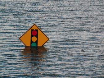 Road sign partially submerged in flood waters