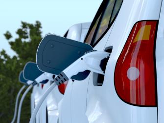 A line of white electric cars charging