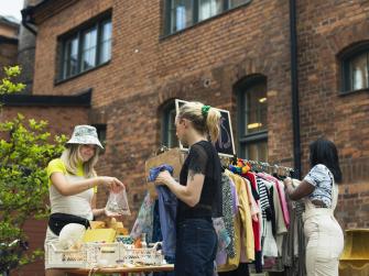 Three people thrift shopping outside